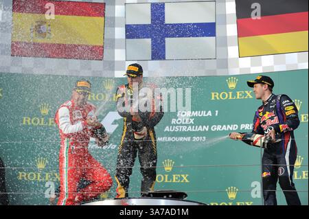17 marzo 2013 - Melbourne, Victoria, Australia - FERNANDO ALONSO (ESP) della Scuderia Ferrari alla guida della Ferrari 056, a sinistra, KIMI RAIKKONEN (fin) della Lotus F1 Team alla guida della Renault RS27-2013, centro, e SEBASTIAN VETTEL (GER) della Infiniti Red Bull Racing alla guida della Renault RS27-2013, a destra, spruzzare champagne sul podio il quarto giorno del Gran Premio d'Australia di Formula 1 2013, Melbourne, Australia. (Immagine di credito: © Theo Karanikos/ZUMAPRESS.com) Foto Stock
