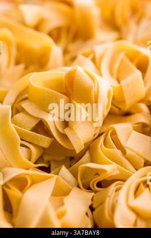 Tagliatelle di pasta italiana. La pasta cruda con spaghetti Foto Stock
