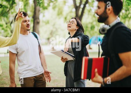 Studenti multiculturali che collaborano all'aperto su progetti scolastici dopo le lezioni Foto Stock