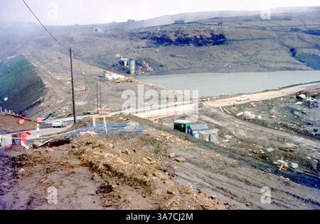 Questa fotografia del 1969 cattura la costruzione del ponte dell'autostrada M62 che attraversa il nuovo Scammonden Reservoir, nei Pennines. Scattata durante una fase chiave di sviluppo, l'immagine mostra i veicoli da costruzione, le impalcature e i lavori di costruzione come parte di uno dei progetti di integrazione di autostrade e dighe più ambiziosi della Gran Bretagna. La struttura avrebbe infine trasportato la M62 attraverso la diga di Scammonden, l'unico caso nel Regno Unito in cui una strada principale corre in cima a un muro della diga. Foto Stock