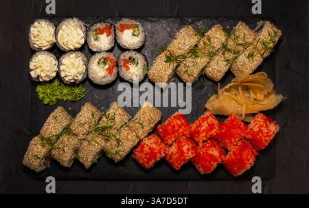 Sushi giapponese assortito su un piatto nero, vista dall'alto Foto Stock