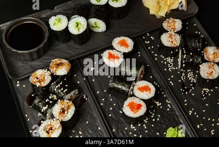 disporre il maki roll con salmone, cetrioli, avocado e anguilla sui piatti con wasabi e zenzero Foto Stock