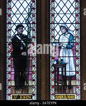 Vetrate colorate raffiguranti due membri dell'ambulanza di San Giovanni. Un portatore di barella maschio e un'infermiera femmina. Cattedrale di Bristol Inghilterra Regno Unito. Marzo 2025 Foto Stock