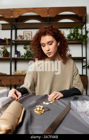 La giovane artigiana crea gioielli complessi con cura nel suo elegante spazio di lavoro. Foto Stock