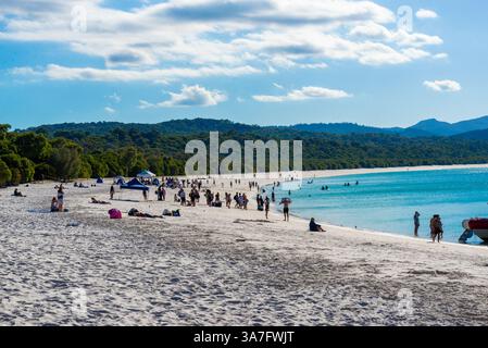 Giornata di sole a Whitehaven Beach con gente che si gode la splendida costa Foto Stock