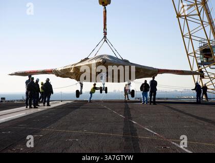26 novembre 2012 - Norfolk, Virginia, Stati Uniti - i marinai della US Navy assistono all'imbarco del dimostratore X-47B Unmanned Combat Air System (UCAS) a bordo della portaerei USS Harry S. Truman (CVN 75). Il veicolo aereo è arrivato con una chiatta dalla Naval Air Station Patuxent River, MD Truman è la prima portaerei ad ospitare operazioni di test per un aereo senza equipaggio. La Marina ha in programma di condurre test sul ponte portaerei X-47B a bordo della nave. (Immagine di credito: © Lorenzo J. Burleson/US Navy/ZUMAPRESS.com) Foto Stock