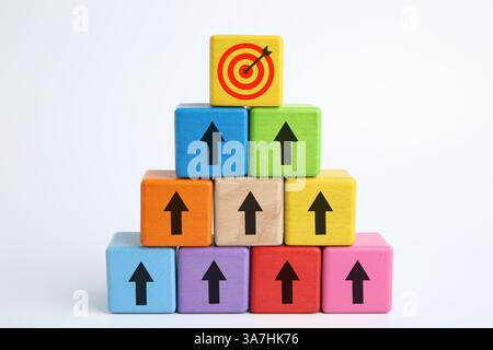 Targeting. Piramide di cubi colorati con frecce che puntano verso uno con un mirino sulla parte superiore su sfondo bianco Foto Stock