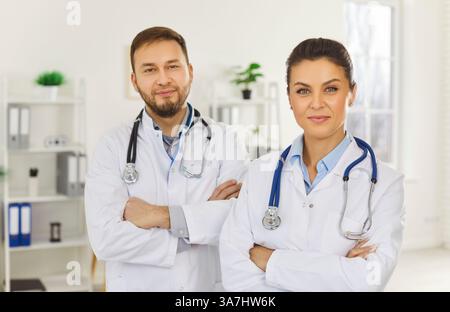 Due medici seri, team maschile e femminile, infermiere che lavorano insieme, un gruppo diversificato che sta insieme Foto Stock