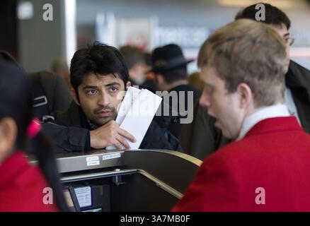 21 dicembre 2012 - Chicago, Illinois, USA - Dhiraj Parwann, centro di Chicago, ascolta un agente dell'American Airlines all'aeroporto internazionale o'Hare, 21 dicembre 2012. (Immagine di credito: © Alex Garcia/MCT/ZUMAPRESS.com) Foto Stock