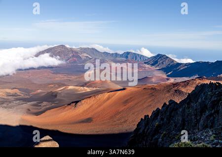 Kula, HI, USA, 12 dicembre 2017: Panorama mozzafiato del terreno vulcanico a Maui, Hawaii, con vivaci crateri rossi e marroni circondati e nuvole Foto Stock