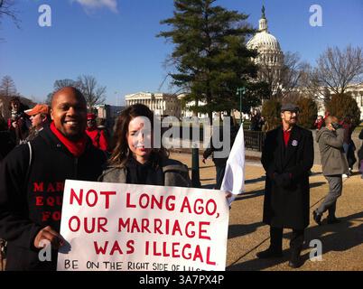 26 marzo 2013 - Washington, DC, USA - Kris White, 32, e Lyssa White, 29, di Manassas, Virginia, dicono che sono sposati da cinque anni, e hanno portato un poster che fa riferimento ad un caso della Corte Suprema del 1967 che ha ribaltato le leggi statali che vietano i matrimoni interrazziali, a Washington, D.C., martedì 26 marzo, 2013. la coppia si è unita ai manifestanti nell'esortare l'attuale Corte Suprema a pronunciarsi a favore del matrimonio gay. (Immagine di credito: © Curtis Tate/MCT/ZUMAPRESS.com) Foto Stock