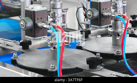 Due macchine con tubi rossi e blu collegati. I tubi sono collegati a una macchina centrale, background industriale Foto Stock