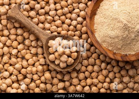 Ceci secchi crudi biologici nel cucchiaio e nel recipiente - Cicer arietinum. Foto Stock