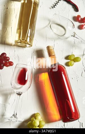 Vista dall'alto dei raffinati vini rossi e bianchi su superficie fessurata tra verricelli e uva Foto Stock