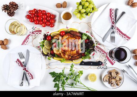 Vista dall'alto del tavolo festivo servito con pollo al forno verdure varie e posto vicino a piatti e frutta Foto Stock