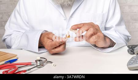Medico ortodontico che mostra un apparecchio acustico per pazienti sordi Foto Stock