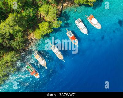 Vista aerea di splendidi yacht e barche sul mare durante il sole estivo. Fethiye Lagoons, Turchia. Vista dall'alto della baia, yacht di lusso, barche a vela, Clear BL Foto Stock