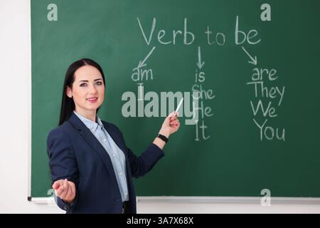 Insegnante di inglese durante la lezione vicino alla lavagna in classe Foto Stock