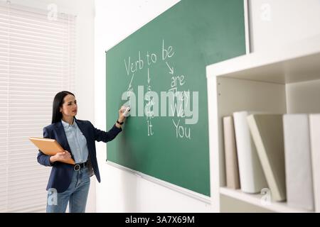 Insegnante di inglese durante la lezione vicino alla lavagna in classe Foto Stock