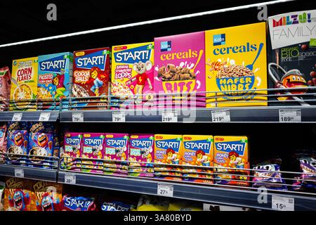 Leopoli, Ucraina - 25 marzo 2025: Scatole colorate di cereali per la colazione disposte su scaffali in una corsia del supermercato. Foto Stock