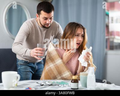 Donna malata che riposa a casa con il marito Foto Stock