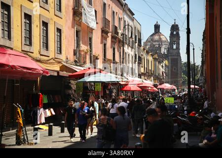 Città del Messico, Messico. 16 marzo 2025. I passanti camminano lungo via Emiliano Zapata nel centro storico di città del Messico. Sullo sfondo si vede la chiesa di la Santísima. (Foto di Apolline Guillerot-Malick/SOPA Images/Sipa USA) credito: SIPA USA/Alamy Live News Foto Stock