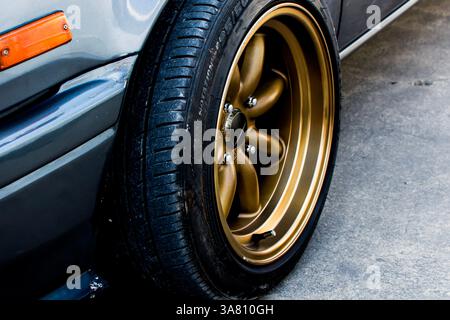 Primo piano del cerchio in lega d'oro con pneumatico, Automotive Concept Foto Stock