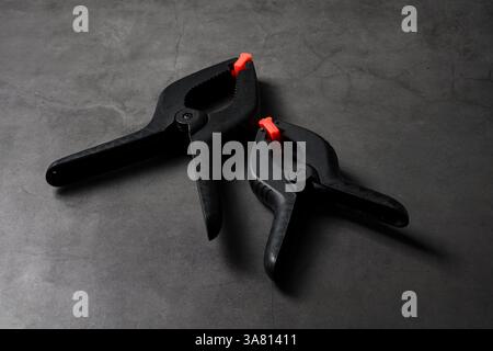 Morsetto in plastica arancione nero su sfondo in pietra grigio scuro Foto Stock