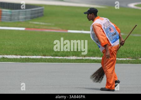 22 marzo 2013 - Sepang, Malesia - ufficiale del Sepang International Circuit Course che pulisce la pista dopo la prima sessione di prove di Formula uno del Gran Premio della Malesia 2013 sul circuito Internazionale di Sepang. (Immagine di credito: © Robertus Pudyanto/ZUMAPRESS.com) Foto Stock