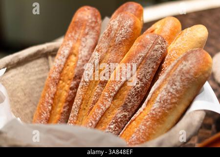 Cestino di baguette artigianali appena sfornate presso un buffet dell'hotel a Manila, Filippine, con crosta dorata e consistenza rustica Foto Stock