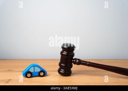 Martello del giudice e macchina blu giocattolo. Informazioni sul traffico e sulle regole di guida. Incidente d'auto, guida ubriaca, tribunale, giustizia Foto Stock