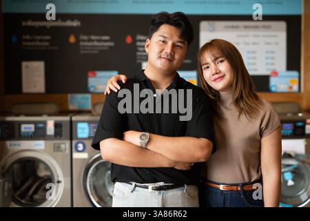 Giovane coppia asiatica fiduciosa nel negozio di lavanderia Foto Stock