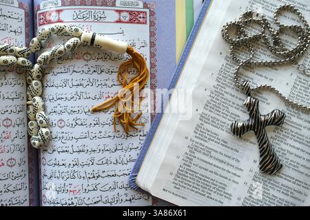 Sacro Corano con perline di preghiera musulmane e Bibbia con rosario, simboli interreligiosi tra cristianesimo e Islam, ho chi Minh City, Vietnam Foto Stock