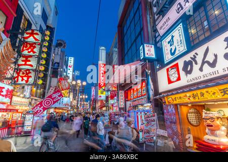 Vista delle colorate facciate dei ristoranti a Dotonbori, vivace quartiere dei divertimenti vicino al fiume, Osaka, Honshu, Giappone Foto Stock