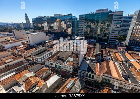 Contrasto urbano - sobrados conservati, antiche case a due o più piani del periodo coloniale e imperiale in Brasile nel cuore della popolare regione commerciale conosciuta come Saara nel centro di Rio de Janeiro, accanto a edifici aziendali moderni - edificio della stazione ferroviaria centrale del Brasile sullo sfondo a sinistra. Un sobrado è un edificio in stile residenziale dell'epoca coloniale portoghese, tipico del Brasile e di altre ex colonie portoghesi. E' una forma equivalente alla casa cittadina anglo-americana, caratterizzata tipicamente da due piani con un balcone, erano le residenze di persone importanti della città. Foto Stock