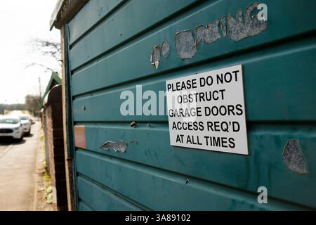 Non ostruire il cartello della porta del garage su una porta del garage usurata Foto Stock