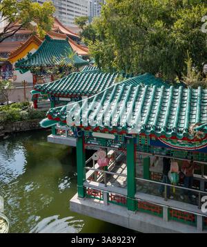 Hong Kong. Cina- 02.24.2025. Vista ad alto angolo dei padiglioni in stile cinese, dei tetti e del laghetto del Good Wish Garden nel complesso del Tempio di Wong Tai sin. Foto Stock