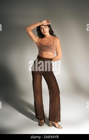 Una splendida giovane donna mostra con fiducia il suo stile estivo elegante e alla moda. Foto Stock