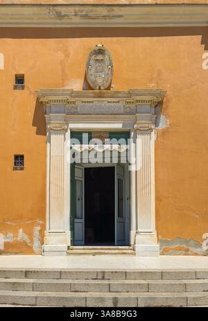 Ajaccio, Corsica, Francia 8 luglio 2024: Cattedrale di Santa Maria Assunta. Porta d'ingresso incorniciata da sculture in pietra di pilastri, stemma e testo Foto Stock