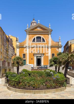 Ajaccio, Corsica, Francia 8 luglio 2024: Facciata anteriore della cattedrale di Santa Maria Assunta di colore marrone beige sotto il cielo blu. Vista dal giardino di Place Mère Teresa Foto Stock