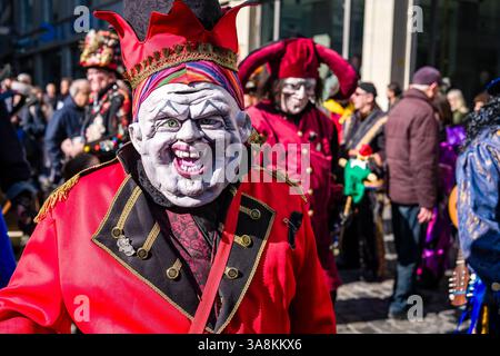 Le persone mascherate celebrano il tipico carnevale di Lucerna nelle strade della città. Foto Stock