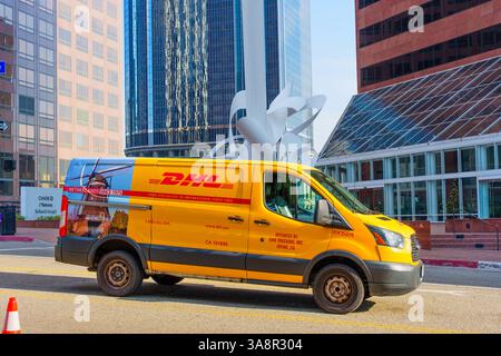 Los Angeles, California - 4 dicembre 2024: Il furgone DHL è parcheggiato in South Hope Street, mostrando l'edificio CBRE e l'architettura moderna a L. Foto Stock