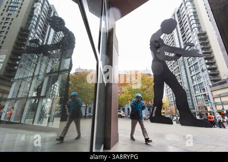 18 ottobre 2017 - Seattle, Washington, Stati Uniti - Seattle, Washington: Woman Walks by the Hammering Man al Seattle Art Museum mentre la prima tempesta della stagione colpisce la città con forti venti e pioggia. Il National Weather Service ha un avviso di vento forte in vigore e un avviso di pioggia pesante durante il fine settimana per la maggior parte della Washington occidentale. (Immagine di credito: © Paul Gordon via ZUMA Wire) Foto Stock