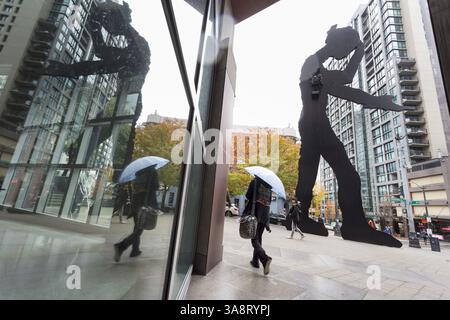 18 ottobre 2017 - Seattle, Washington, Stati Uniti - Seattle, Washington: Woman Walks by the Hammering Man al Seattle Art Museum mentre la prima tempesta della stagione colpisce la città con forti venti e pioggia. Il National Weather Service ha un avviso di vento forte in vigore e un avviso di pioggia pesante durante il fine settimana per la maggior parte della Washington occidentale. (Immagine di credito: © Paul Gordon via ZUMA Wire) Foto Stock