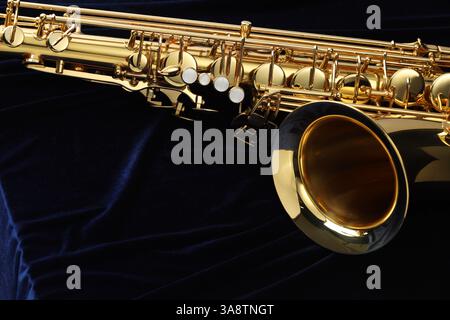 Jazz. Un bellissimo sassofono su tessuto blu scuro, primo piano. Spazio per il testo Foto Stock