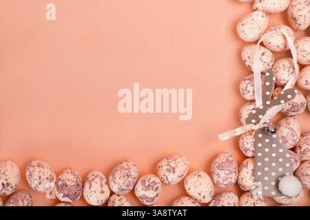 Uova di Pasqua e carta carina coniglietto pasquale su sfondo rosa pastello con spazio negativo Foto Stock