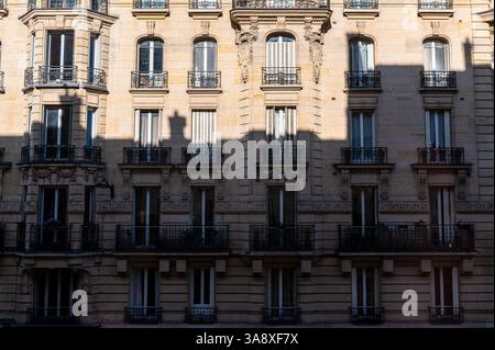 Facciata tipica di stile Haussmann di un vecchio edificio a Parigi, in Francia, con una grande ombra su di esso Foto Stock