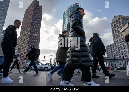 Berlino, Berlino, Germania. 29 marzo 2025. Gli acquirenti e i turisti hanno passeggiato lungo la Tauentzienstrasse e Potsdamer Platz di Berlino sabato 29 marzo 2025, curiosando tra i negozi di punta sotto alberi primaverili in fiore mentre la Germania si trova di fronte a una crescente incertezza economica. Un tempo simbolo della fiducia dei consumatori dopo la riunificazione, il vivace viale è ora un campanello di sentimenti mutevoli. Nonostante il sole, i rivenditori segnalano la presenza di folle più sottili e portafogli più stretti. L'economia della Germania, da tempo acclamata come motore industriale europeo, sta sputando. Le grandi aziende hanno annunciato tagli radicali di posti di lavoro, citando il cervo Foto Stock