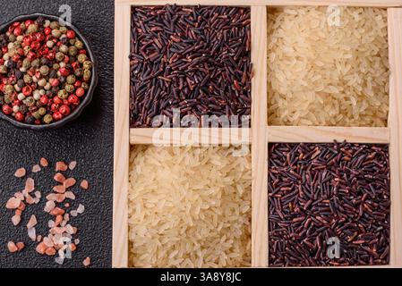 Grani di riso crudo bianco e rosso in un recipiente di ceramica. Riso come ingrediente di cibo biologico asiatico Foto Stock
