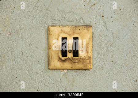 Vecchio interruttore doppio sporco sulla vecchia parete in officina, interruttore a parete Foto Stock